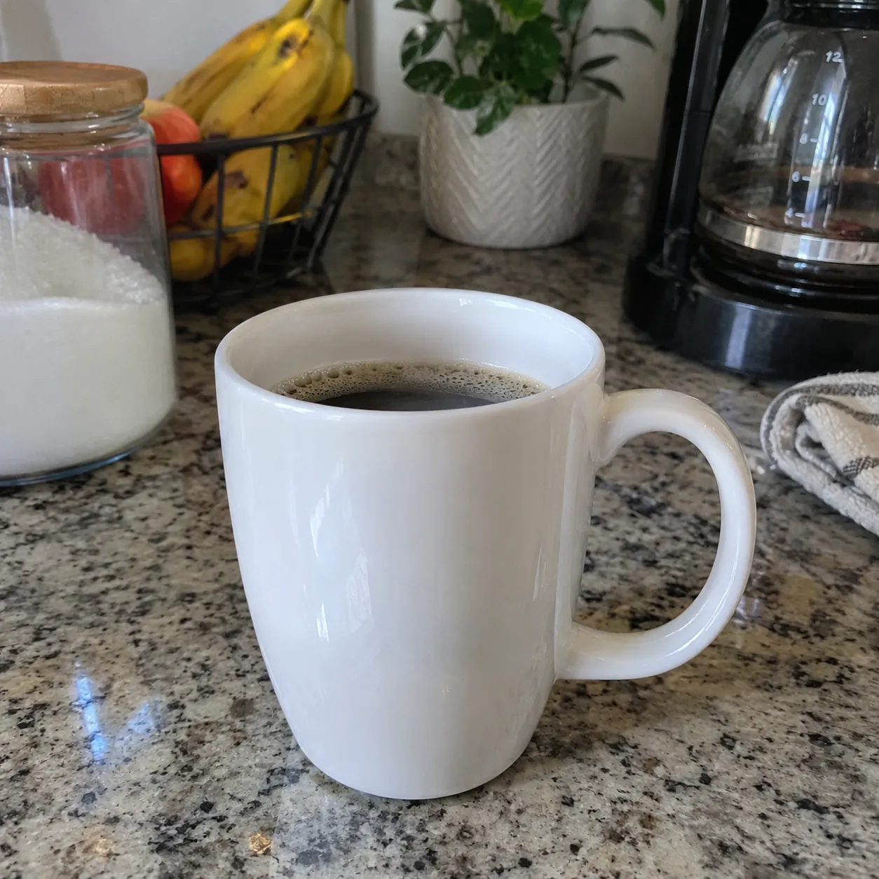 A plain smartphone photo of a white ceramic coffee mug on a kitchen counter, ordinary daylight, slightly cluttered background